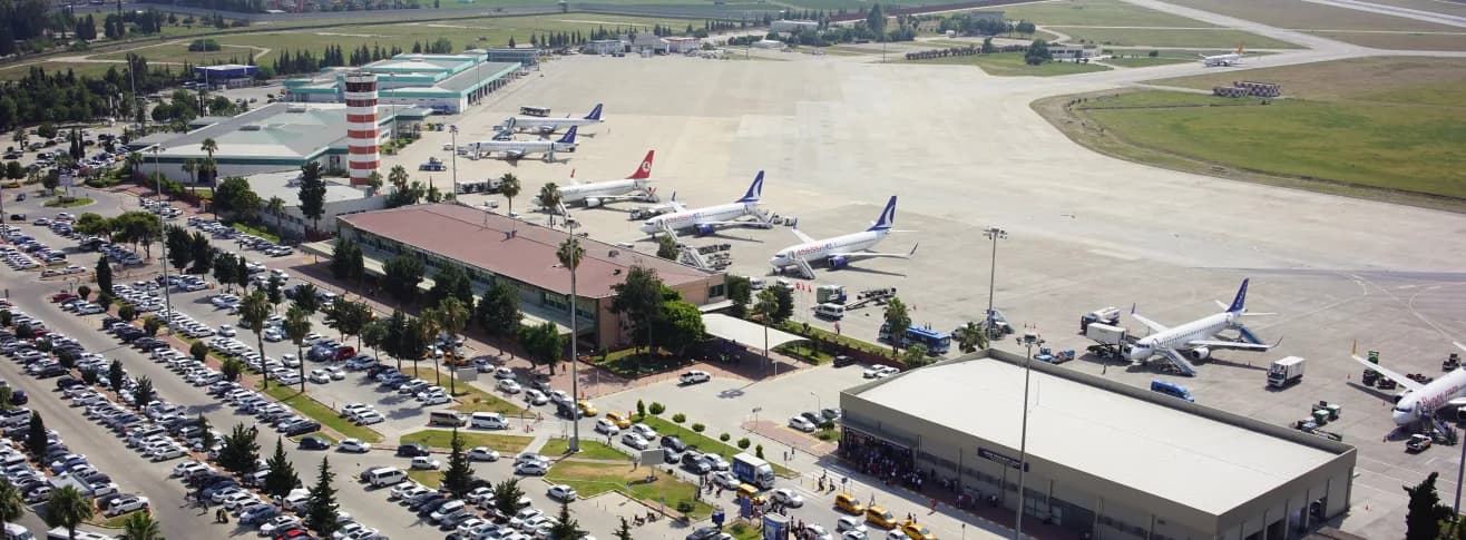 DHMİ Adana Havalimanı'nın kuşbakışı görünümü: terminal binası, apron ve park halindeki uçaklar